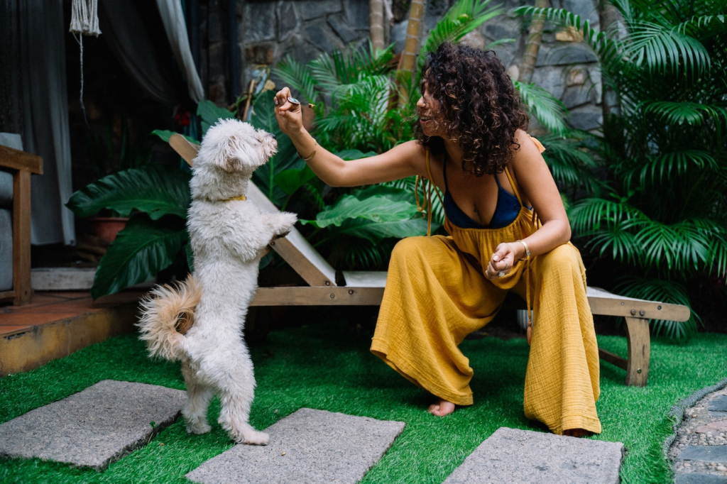 A woman feeding her dog a treat